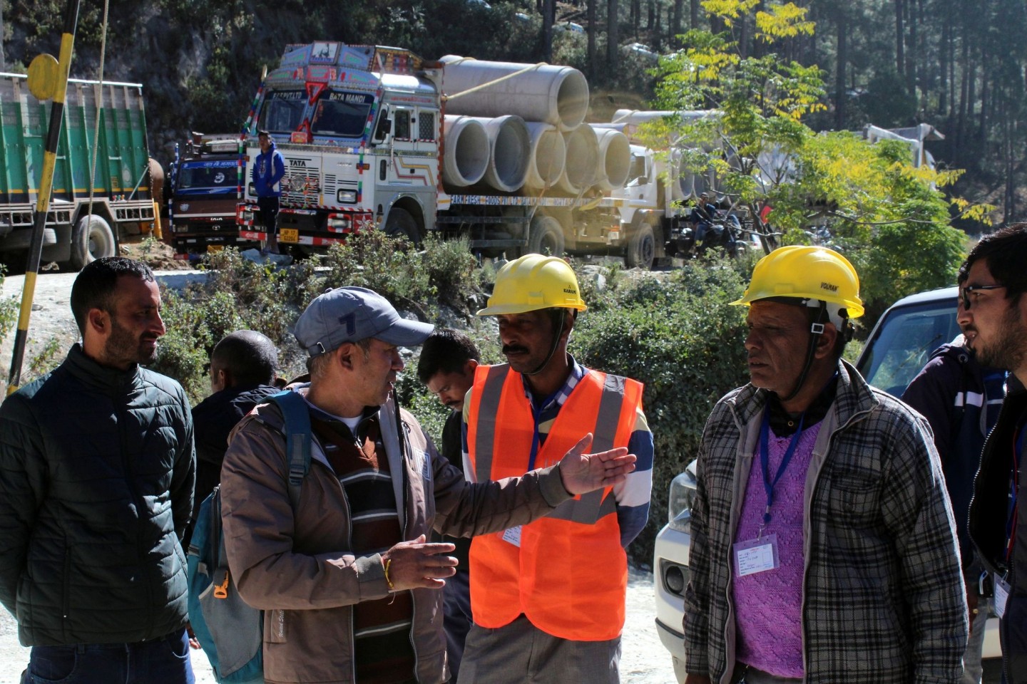 Retter beraten sich vor dem teilweise eingestürzten Straßentunnel im indischen Silkyara.